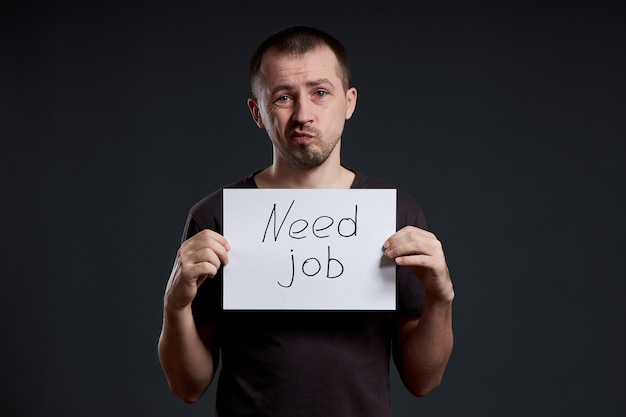 Foto o homem procura trabalho, desemprego e crise. emoções diferentes no rosto, um sinal nas mãos