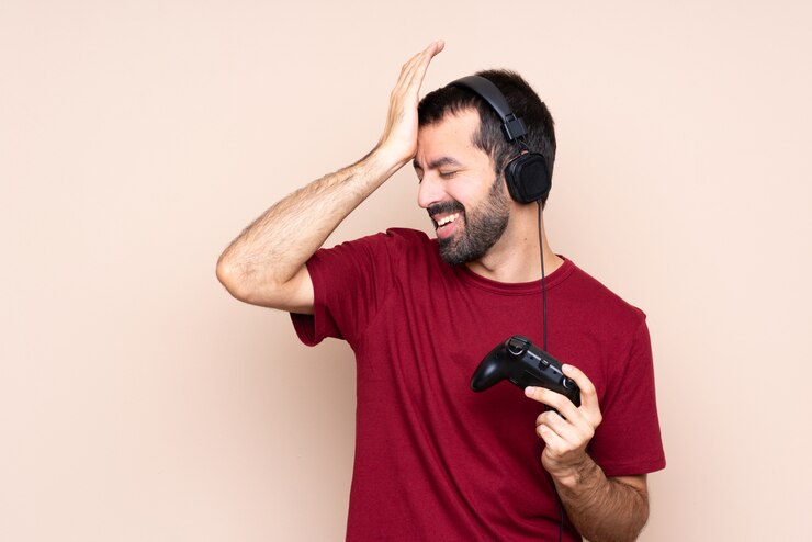 Foto o homem que joga com um controlador de videogame em uma parede isolada percebeu algo e pretendia a solução
