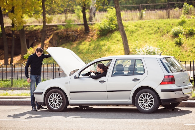 O homem queria ajudar uma jovem a consertar o carro, mas não sabe qual é o problema.