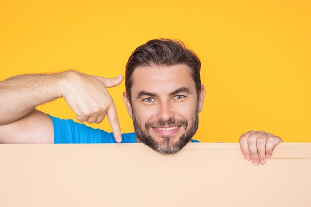 O homem segura o cartaz de cartão em branco pronto para o sinal do seu produto para o seu homem de texto mostrando o sinal em branco bo