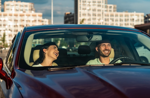 O homem sorridente e a mulher sentados no carro