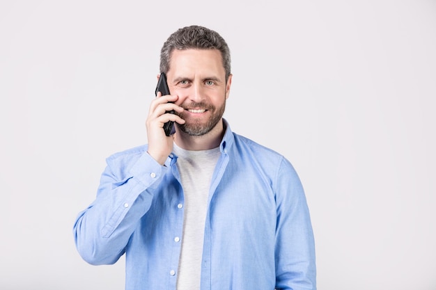 O homem sorridente tem uma chamada de comunicação no telefone isolada no fundo do estúdio