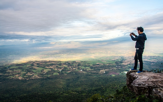 O homem tira foto na montanha do penhasco