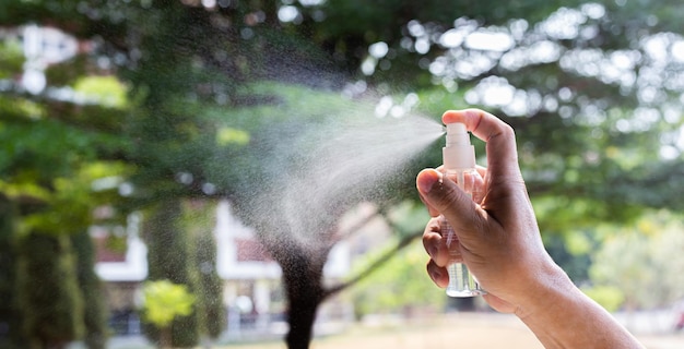 Foto o homem usa um spray de álcool para se livrar de bactérias e vírus