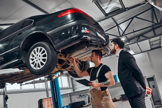 O homem veio à oficina para tirar o carro da manutenção e conversar com os mecânicos sobre o trabalho