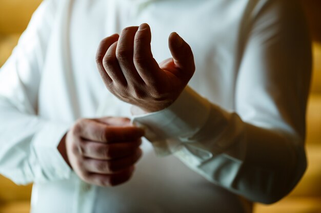 O homem veste um terno de casamento e acessórios no dia do casamento.