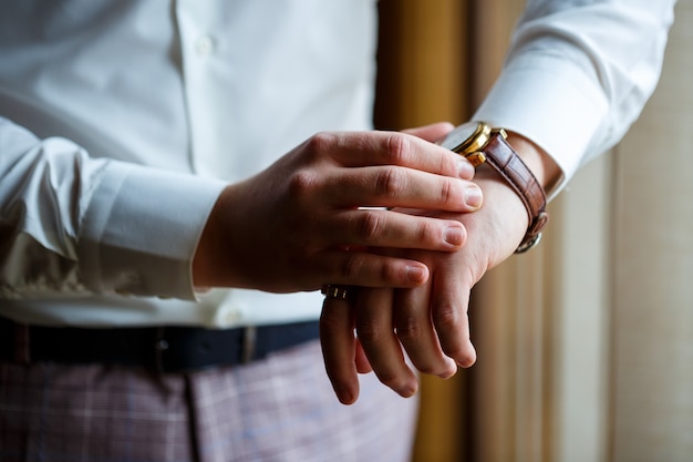 O homem veste um terno de casamento e acessórios no dia do casamento.