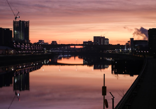 O horizonte de Glasgow refletido no rio Clyde durante um belo nascer do sol