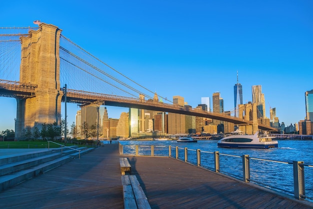 O horizonte de Manhattan com a paisagem urbana da ponte do Brooklyn da cidade de Nova York, nos Estados Unidos da América, ao nascer do sol