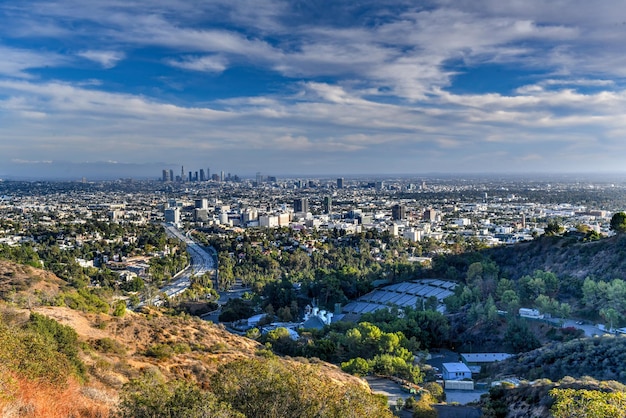 O horizonte do centro de Los Angeles sobre o céu nublado azul na Califórnia de Hollywood Hills