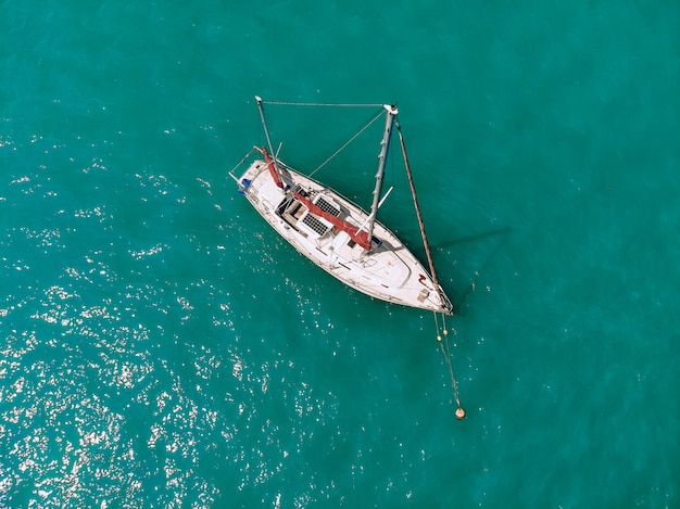 O incrível barco a vela está navegando no mar de um azul profundo. Vista do topo.