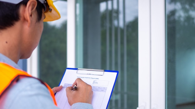 Foto o inspetor ou engenheiro está verificando a estrutura do edifício e os requisitos da pintura de parede. após a conclusão da reforma