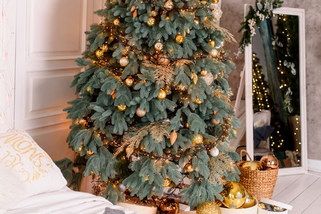 O interior da sala de estar em estilo natalino com um grande abeto e presentes de natal