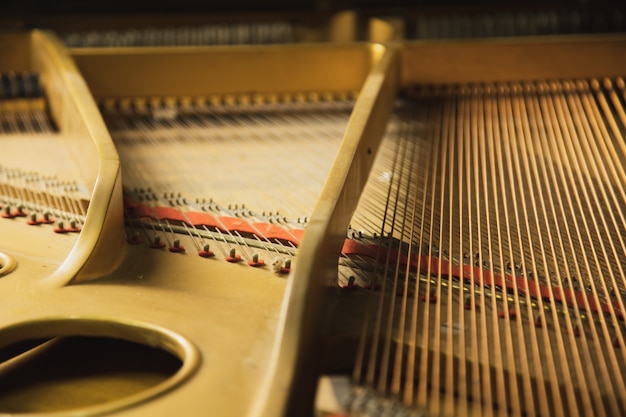 O interior de um instrumento de piano de cauda clássico com cordas de cordas de cobre.