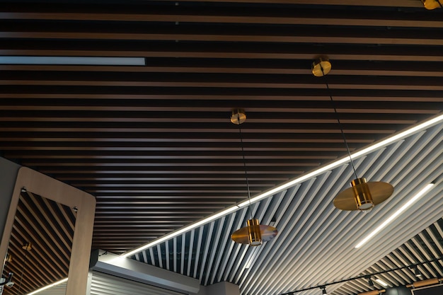 O interior de um restaurante ou café Belo design de teto em um novo apartamento alugado Cobertura de madeira no teto e grandes lâmpadas redondas