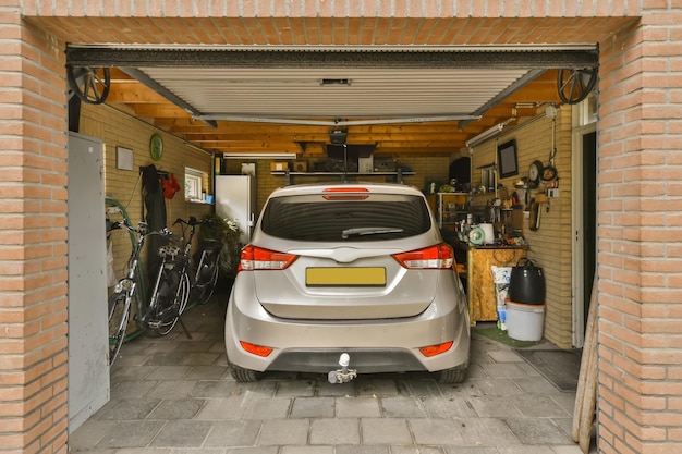 Foto o interior de uma garagem com um carro estacionado e duas bicicletas penduradas na lateral da garagem