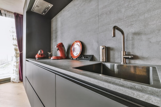 O interior de uma pequena cozinha em estilo preto e minimalista em um apartamento moderno