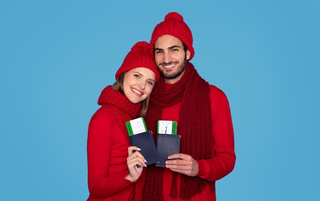 O inverno viaja feliz jovem casal segurando passaportes com bilhetes de embarque