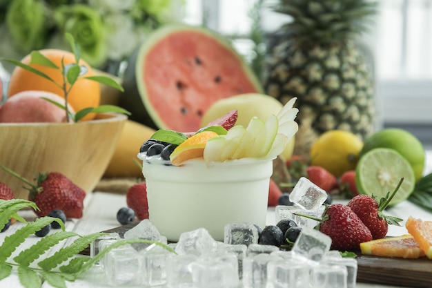 O iogurte de salada de frutas na tigela de vidro