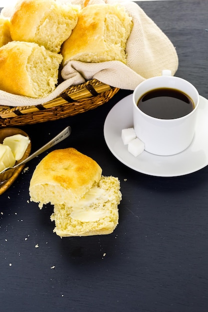 O jantar de massa fermentada recém-assado rola sobre fundo preto.