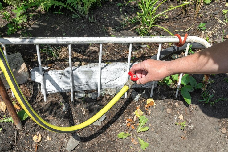 O jardineiro abre a torneira para regar os canteiros