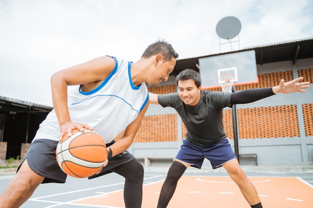 O jogador de basquete dribla a bola cara a cara com o jogador adversário