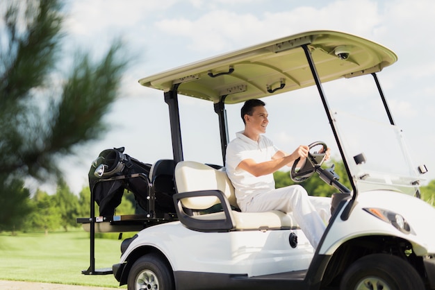 O jogador de golfe novo conduz o divertimento do luxo do carro do golfe.