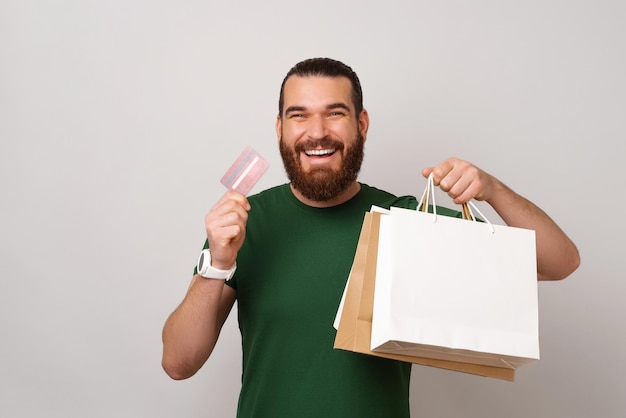 O jovem barbudo em êxtase está feliz por poder pagar agora com seu cartão