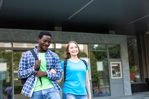 O jovem casal de diversos estudantes deixa o prédio da universidade