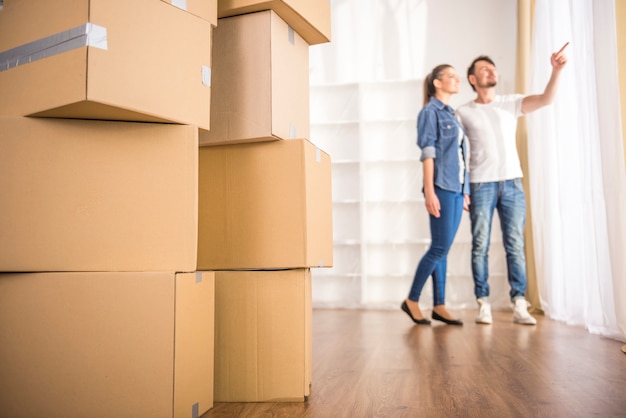 O jovem casal feliz olhando em volta de seu novo apartamento.