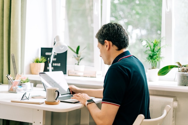 O jovem digitando no laptop