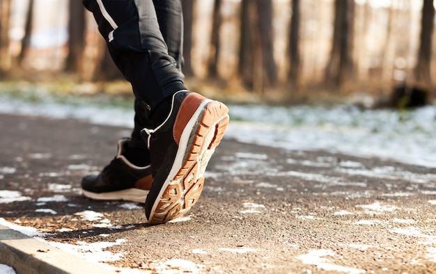 O jovem está correndo no parque de inverno