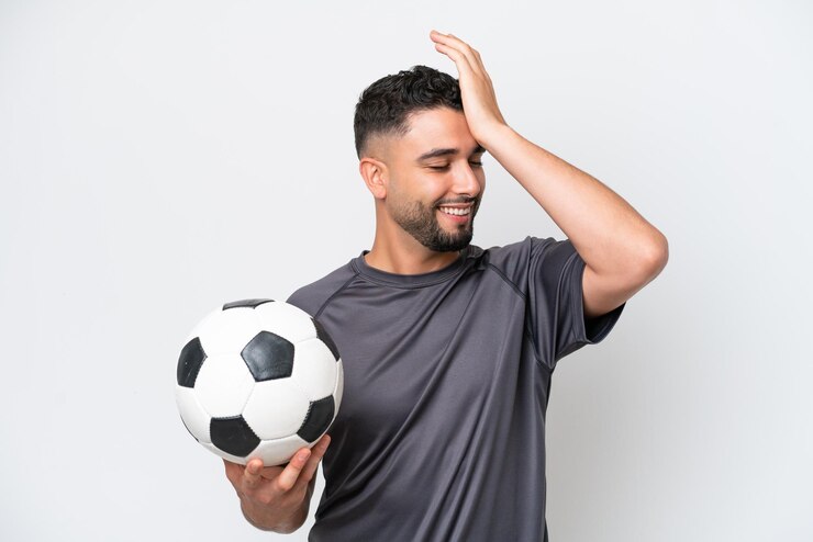 Foto o jovem jogador de futebol árabe isolado no fundo branco percebeu algo e pretende a solução