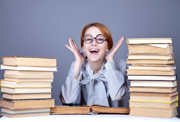 O jovem professor de óculos com livros.