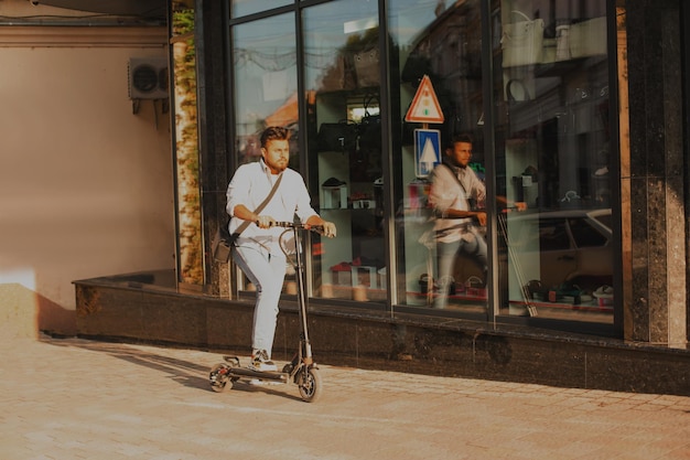 O jovem tem bom humor enquanto monta uma scooter elétrica