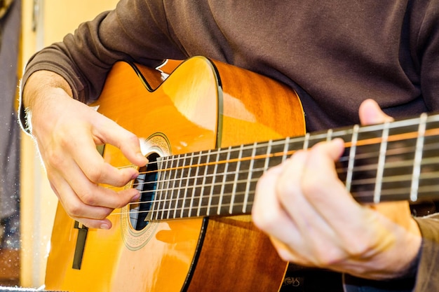 O jovem tocando violão Atirando em contraluz