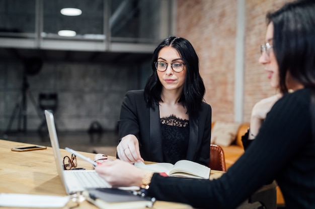 O jovens mulheres interior usando computador portátil