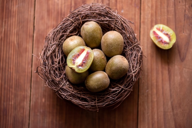 O kiwi cortado é colocado em um prato sobre uma mesa de madeira