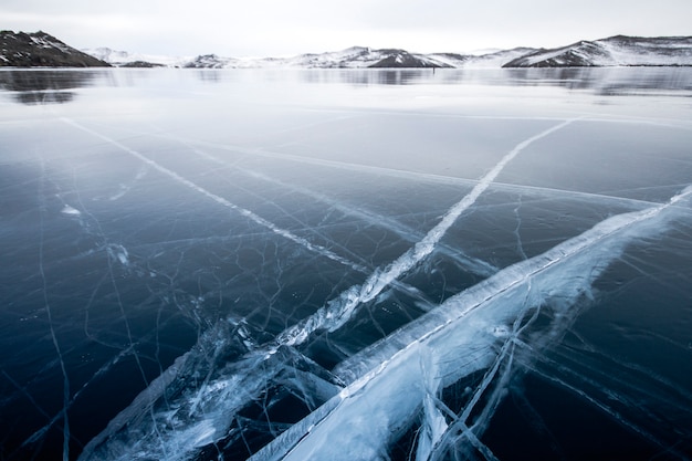 O lago baikal está coberto de gelo e neve, frio e geada fortes, gelo azul claro e espesso