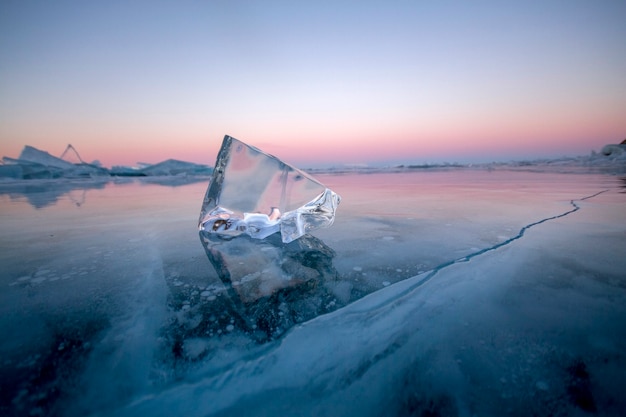 O Lago Baikal está coberto de gelo e neve, um frio forte e um gelo azul claro e espesso. Pingentes de gelo estão pendurados nas rochas. O Lago Baikal é um dia gelado de inverno. Lugar incrível, herança, beleza da Rússia