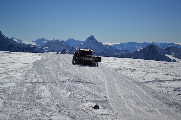 Foto o limpa-neve nas montanhas limpa a estrada da neve