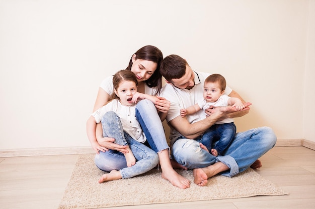 O lindo casal com seus filhos fofos sentados no chão