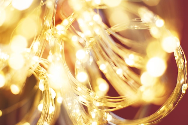 O lindo ouro brilhante de Natal e o fundo vermelho brilham em um bokeh festivo e desfocado