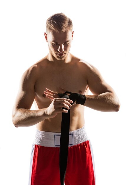 Foto o lutador envolve as mãos com uma banda elástica. preparação para o boxe. esportes de luta.