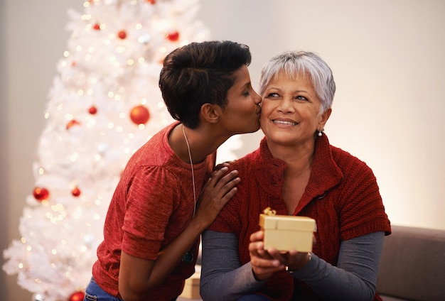 O maior presente é dar Uma mãe e filha trocando presentes no Natal