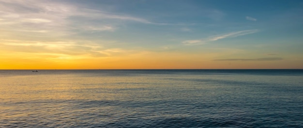 O mar à noite com a luz do sol brilhando dourado no pôr do sol do mar