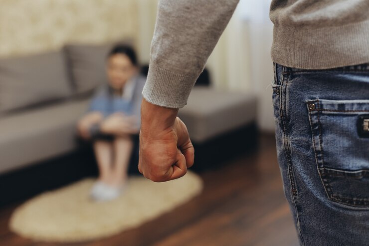 O marido alcoólatra bate na esposa com o punho. Zhenzhina se cobre com as mãos. Violência na família