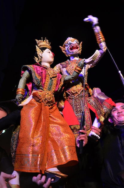 O marionetista profissional tailandês ou o mestre de marionetes manipulam o brinquedo de marionetes antigos atuantes ou marionete antiga no palco para show no evento do festival noturno em SamYan em 22 de maio de 2011 em Bangkok Tailândia