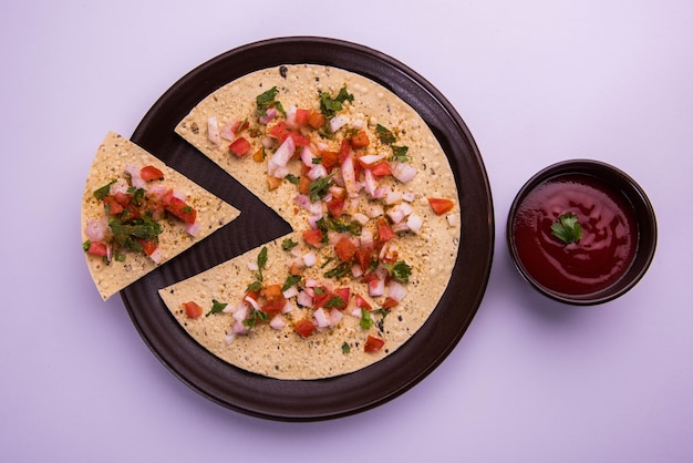 O Masala papad é uma entrada ou comida crocante vegetariana indiana que é muito fácil de preparar. Servido com ketchup de tomate sobre um fundo mal-humorado. Foco seletivo