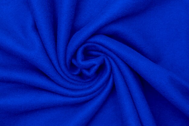 O material macio de lã de fundo com relevo dobra a cor azul brilhante.